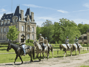 Balade à cheval devant le château du domaine Les Bois-Francs à Center Parcs