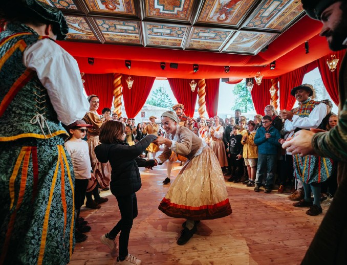 La Frairie de la Toussaint au Puy du Fou, avec visiteurs et artistes dansant sous le baldaquin